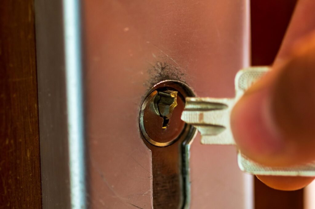 Key stuck in front door lock with hand trying to remove it