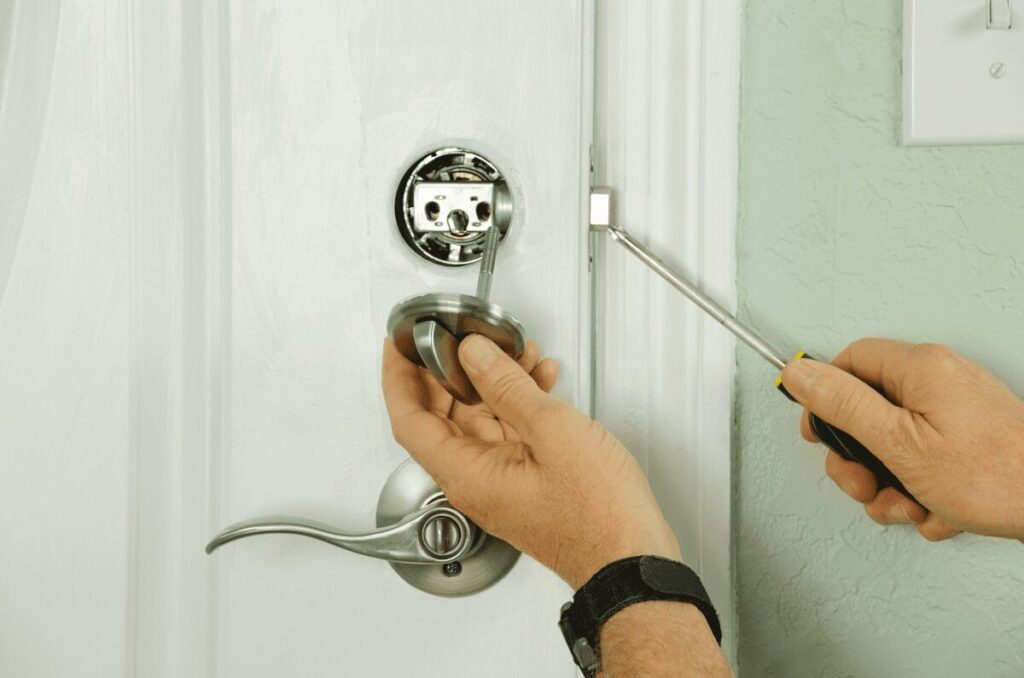 Residential locksmith installing a new deadbolt on a front door