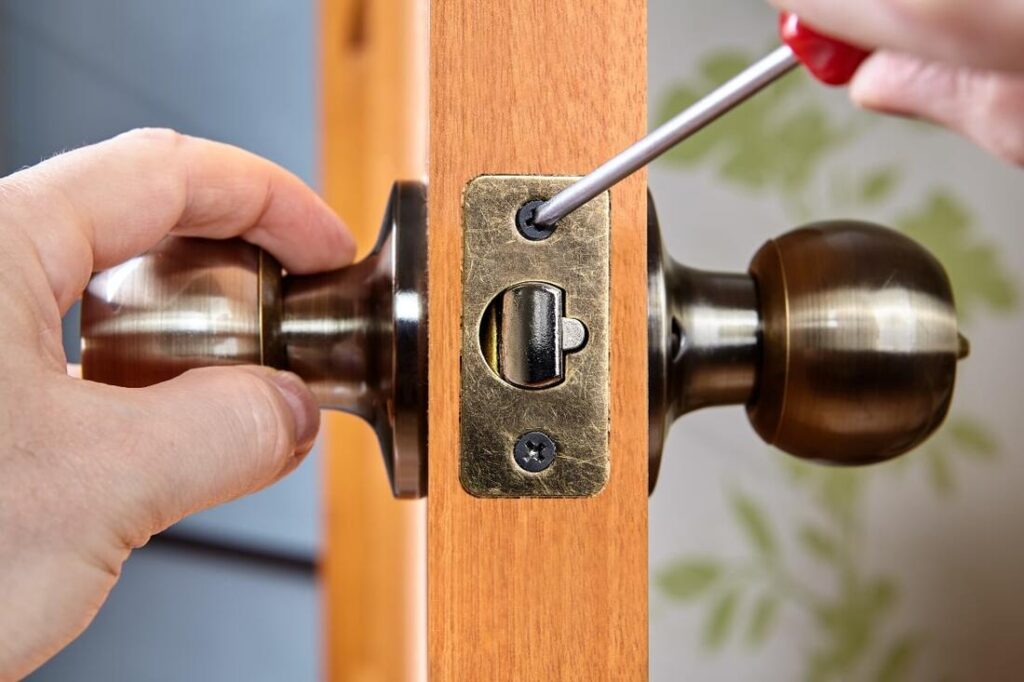 Old, rusty door lock being replaced by a new modern lock
